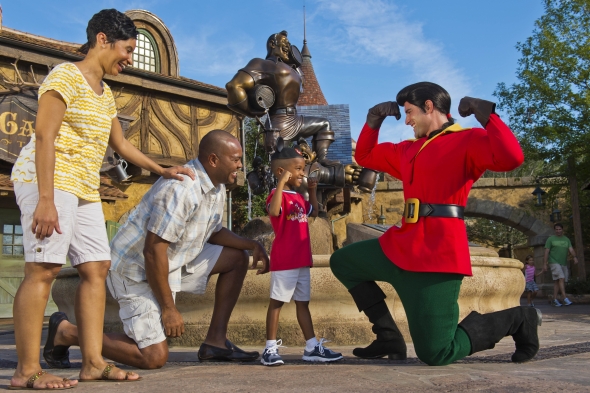 Little boy flexing next to Gaston while family smiles
