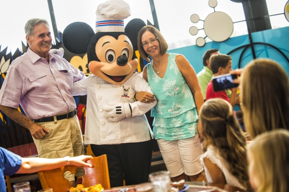 Elderly couple posing with Chef Mickey