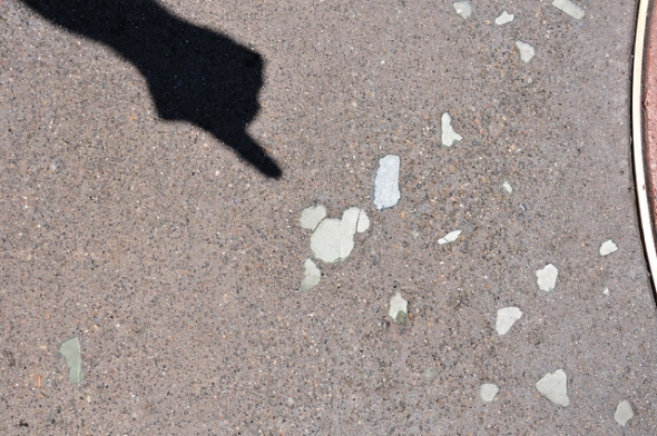 Hidden Mickey on the concrete with a shadowed finger pointing