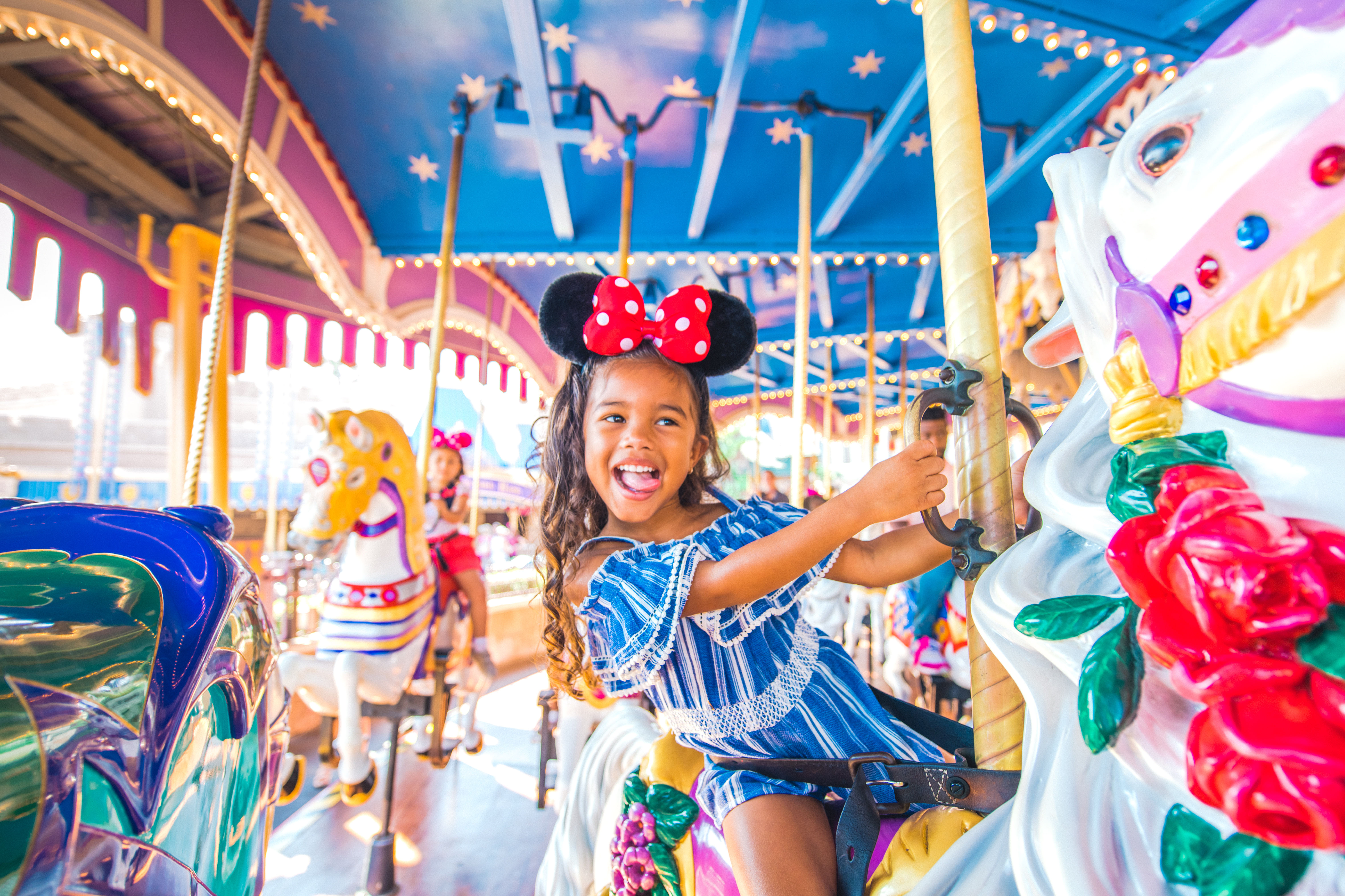 Adorable girl in Minnie Ears on carousel