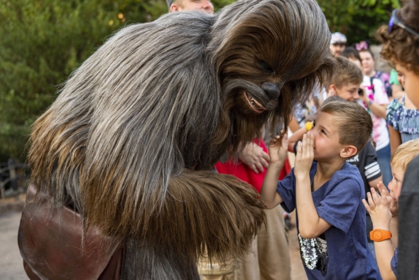 A child whispers to Chewie