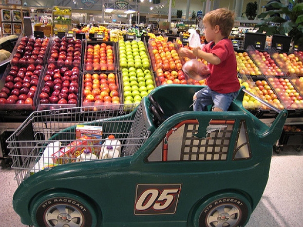 Kid in grocery cart at store