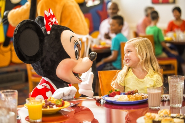 Minnie greets a little girl at Chef Mickey's