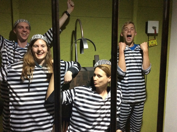 Escape room participants in prison jumpsuits