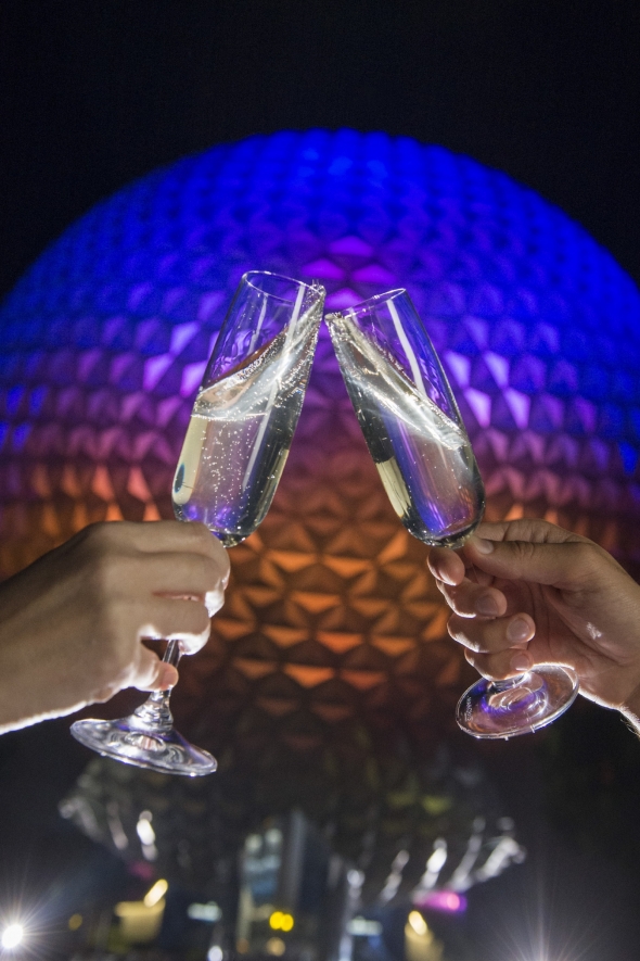 Toasting glasses in front of Spaceship Earth