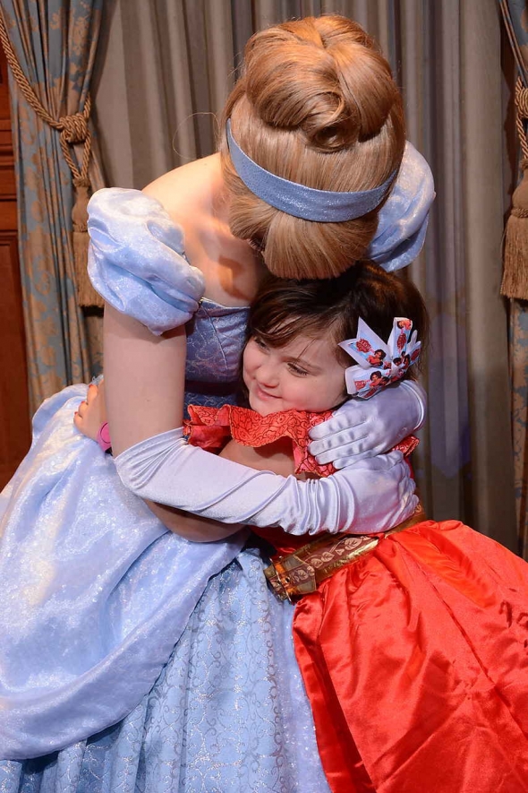 Adorable little girl hugging Cinderella