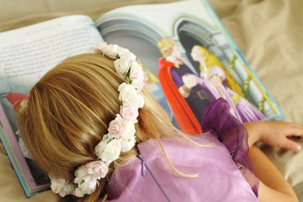 Little girl in princess dress asleep on storybook