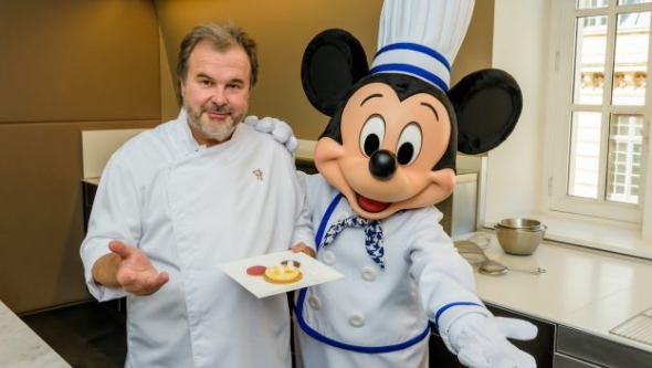 Disney dessert chef posing with Mickey Mouse