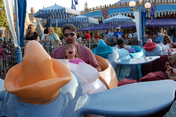 Toddler girl crying while dad holds her on Dumbo